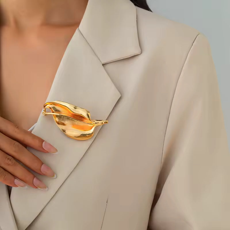 Broche fleur de lys métallique portée sur une tenue